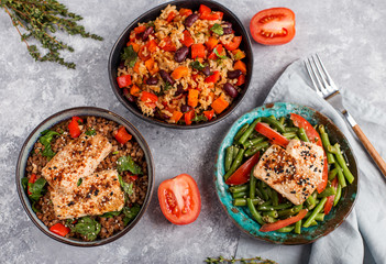 three vegan dishes on a grey concrete background, top view