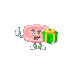 Smiley pink soap cartoon character holding a gift box