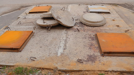 urban sewage wells on the street, rusty iron and concrete sewer manholes