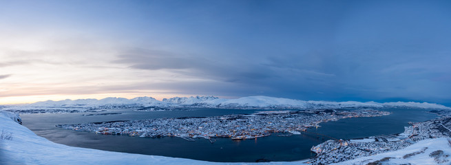 In snow covered mountains of norway during winter while sunset with warm colors