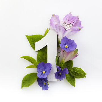 Creative layout with colourful flowers and number one. Flat lay. Top view.