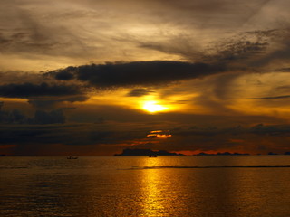 Naklejka na ściany i meble Sunset in the clouds at sea
