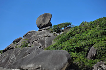 Rock Sail in Thailand. Ancient cliffs, in some places covered with green shrubs. Against the blue sky, a huge stone in the form of a sail.
Similan Islands