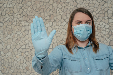 Woman social distancing from corona virus covid-19 wearing a protective white face mask and medical...