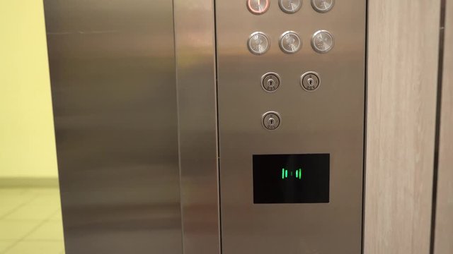 Magnetic card reader in the elevator. A man put a card to the reader and selects the floor.