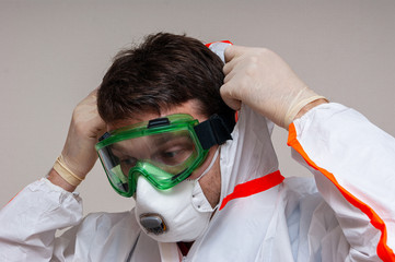 medical officer puts on a protective suit