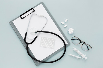Clipboard and stethoscope on medical desk top view