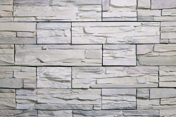 Fototapeta premium Texture of artificial white facing stone tiles. Background, material for the design.