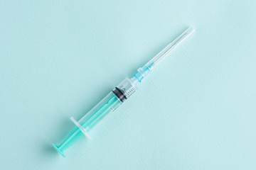 one syringe on blue background, vaccination, inoculation concept