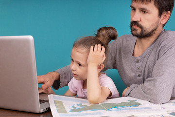 Preteen schoolgirl with dad do her homework with a notebook at home. Child using gadgets for learning. Education and distance learning for children. Studying at home during quarantine. Stay at home