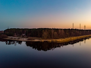 Naklejka premium Areal drone view of small river near pine tree forest.