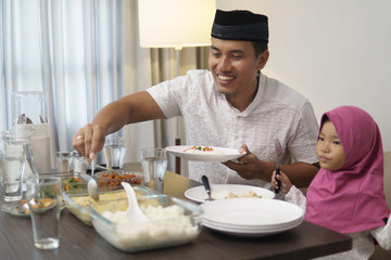 muslim man breakfasting dinner with his daugther and family at home