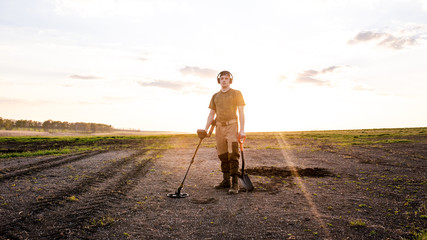 A man is looking for a treasure with a metal detector