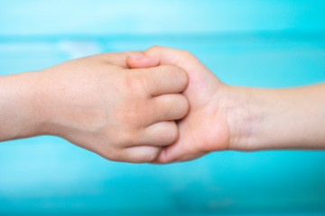 Strong handshake of children as a symbol of truce and friendship