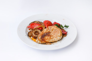 Chicken fillet steak with grilled 
eggplant and pepper. Restaurant dish
decorated with onions on white plate  on white background.