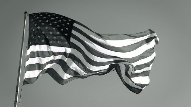 American Flag Slow motion Waving, Black and White. Black and white American USA flag waves in the breeze, bottom view. American flag flying in the wind, BW video. Monochrome American Flag Flies