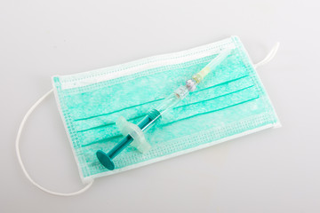 Safety medical surgical protective face mask and syringe in coronavirus concept covid-19