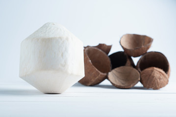 Drinking coconut and split brown coconuts in the white background.