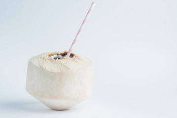 Fresh coconut with straw inside on white background.