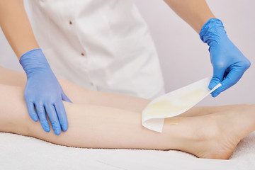 the procedure shugaring. removing sugar paste from the skin surface using a cloth strip