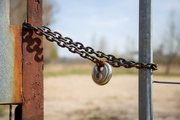 Rostige Metallkette mit rundem Schloss und der Aufschrift 