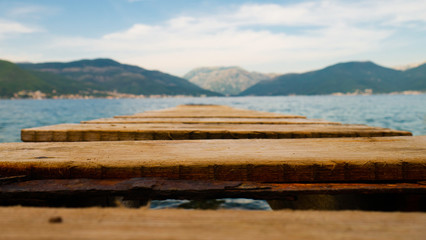 Wooden jetty towards the sea and the mountains - Bay of Kotor, Montenegro.