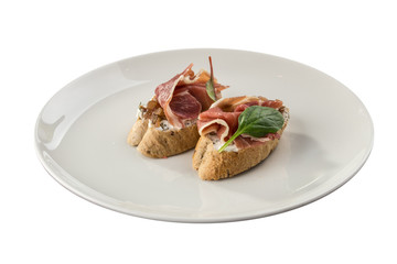 Toast with serrano jamon, prosciutto crudo Italian antipasti with bread bruschetta isolated on white background