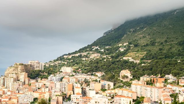 Time-lapse of cloud cover on the hills above Monaco with houses in the foreground
