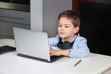 e-learning from home - lovely young boy working with his computer smiling