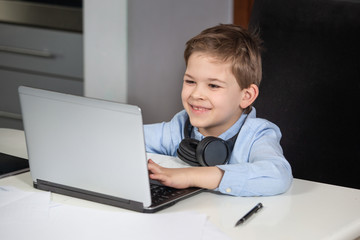 e-learning from home - lovely young boy working with his computer smiling