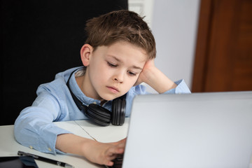 e-learning from home - tired young boy working with his computer being sad