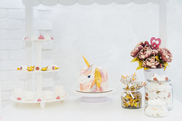 Unicorn birthday cake close up on light.