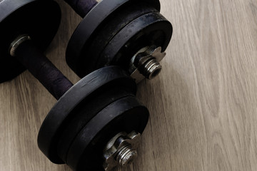 black color old rusty dumbbells on wood floor surface