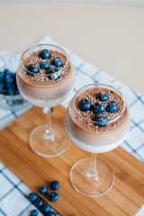Delicious and delicate creamy Italian dessert Panna Cotta made from chia seeds in milk and chocolate mass. Decorated with fresh blueberries and crumbs of milk chocolate. Healthy eating.