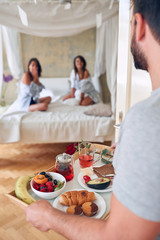 gay couple in bed having  breakfast in bed  together. © luckybusiness