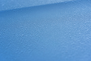Raindrops on the hood of the car. Close-up.