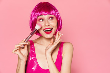 Image of young happy girl wearing wig smiling and holding powder brush