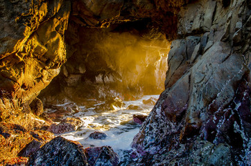 The rays of the sun shine through a hole in the stone, Pfeiffer Beach 