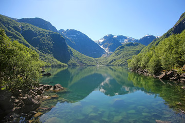 Fototapeta na wymiar Bondhus Lake with beautiful scenery & reflections in the water. The lake is reached along the mountain hike, near Rosendal, Folgefonna National Park, Norway.