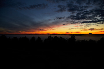 Morning sky, beautiful dark sunrise in russia. Fog at dawn. Cloudy morning. 