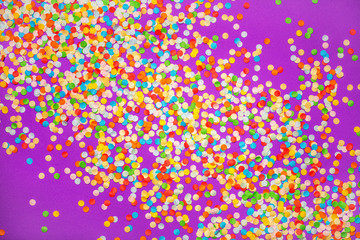 Purple background with vivid confetti. Colorful abstract backdrop with scattered paper circles. Beautiful decor for the party. Festive composition for celebration. View from above. Flat lay