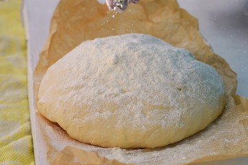 Pizza dough or baking on a white black background of wood. Pastry for bread, dough or pizza/ Woman chef preparing bread