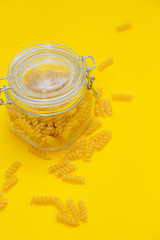 The closed bank with italian pasta on yellow background. Food delivery, coronavirus, crisis concept. Flat lay and place for text.