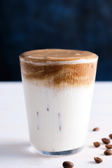 Ice coffee with milk on the white wooden table. Copy space.