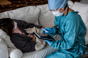 ソファに横たわる患者の診察をする医師