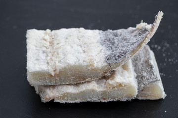 dry cod fish on black ceramic background