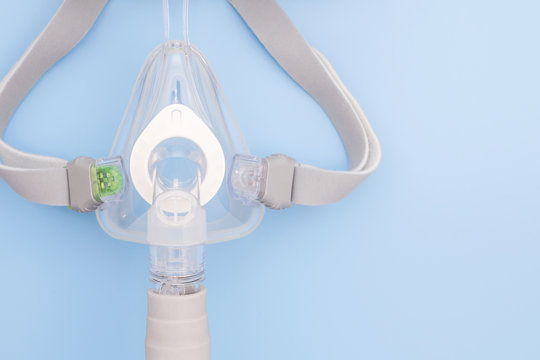 Sleep apnea CPAP mask on blue background. respiratory mask.