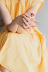 Obraz premium A young girl's thin hands. Girl in a yellow dress 