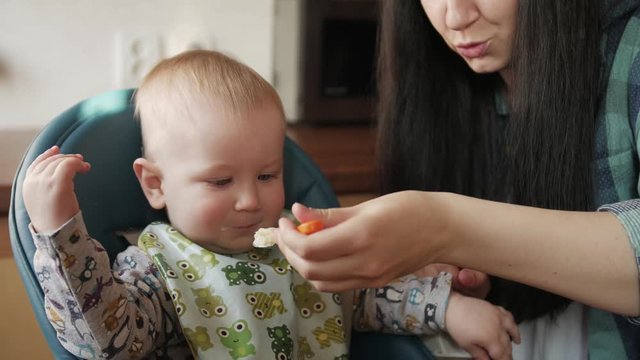 Young mother feeding her baby son