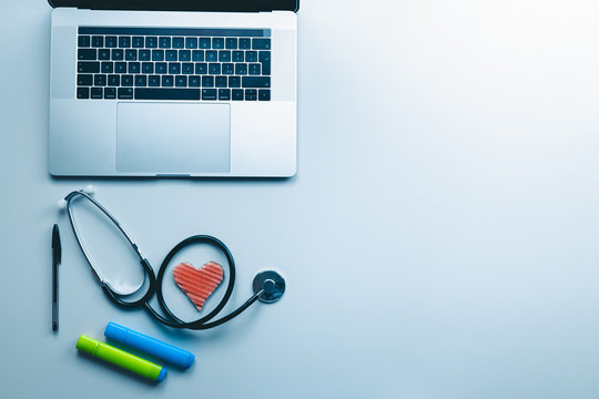 La scrivania di un medico con computer stetoscopio e simbolo del cuore